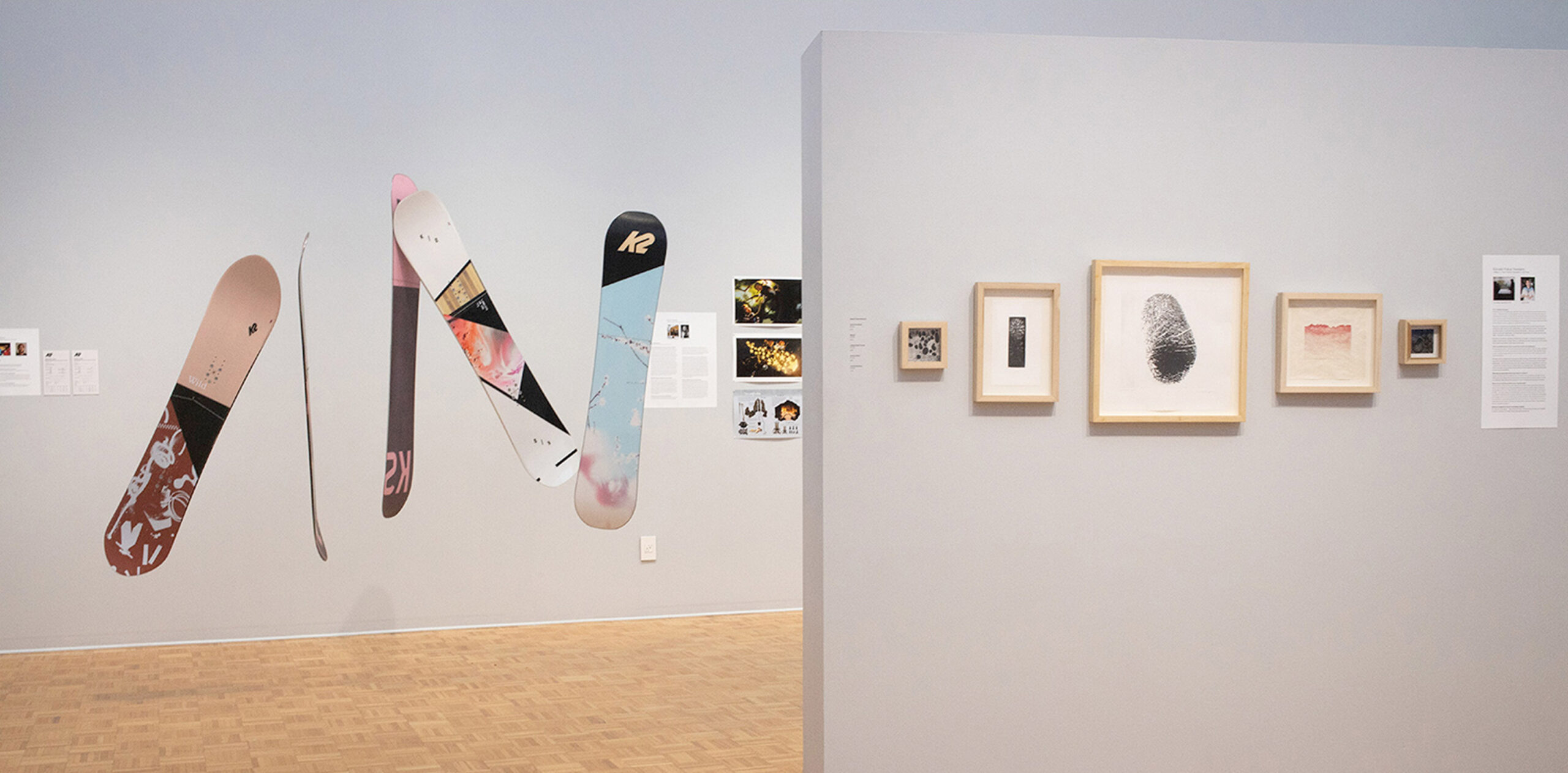 inside-of-a-university-gallery-with-varying-artwork-center-stage-is-snowboards-suspended-from-the-ceiling-anjes-design